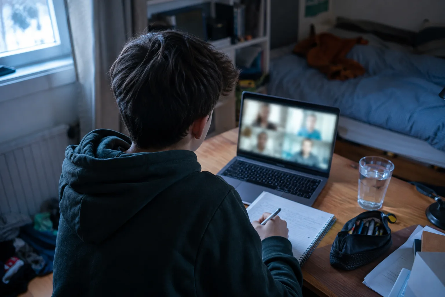 Un adolescent suit une séance de tutorat en ligne depuis sa chambre